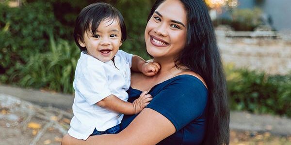 A smiling mother carrying a child